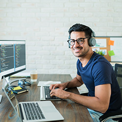 Computer programmer sitting at a desk writing lines of code